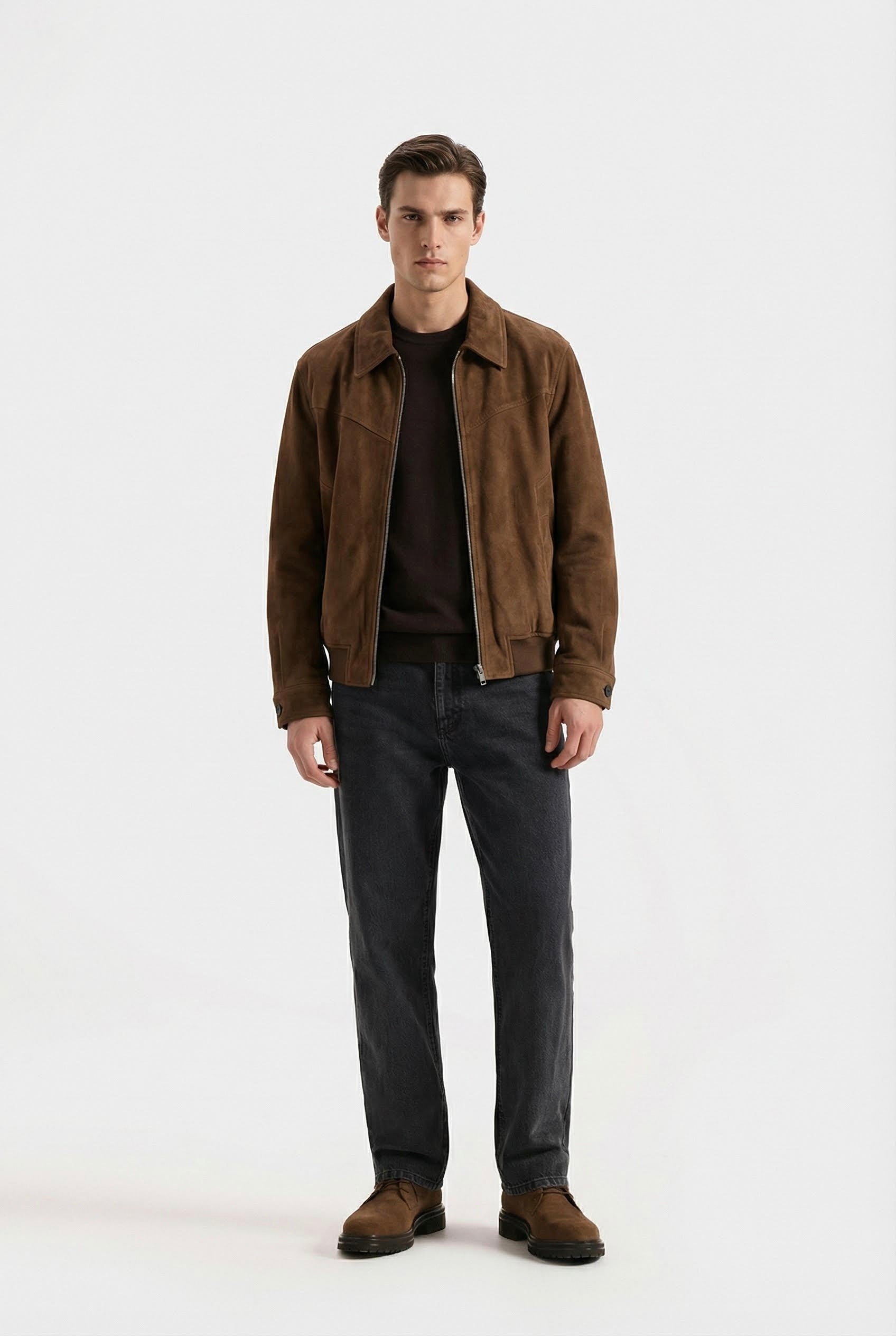 Man wearing a brown jacket and dark pants on a white background