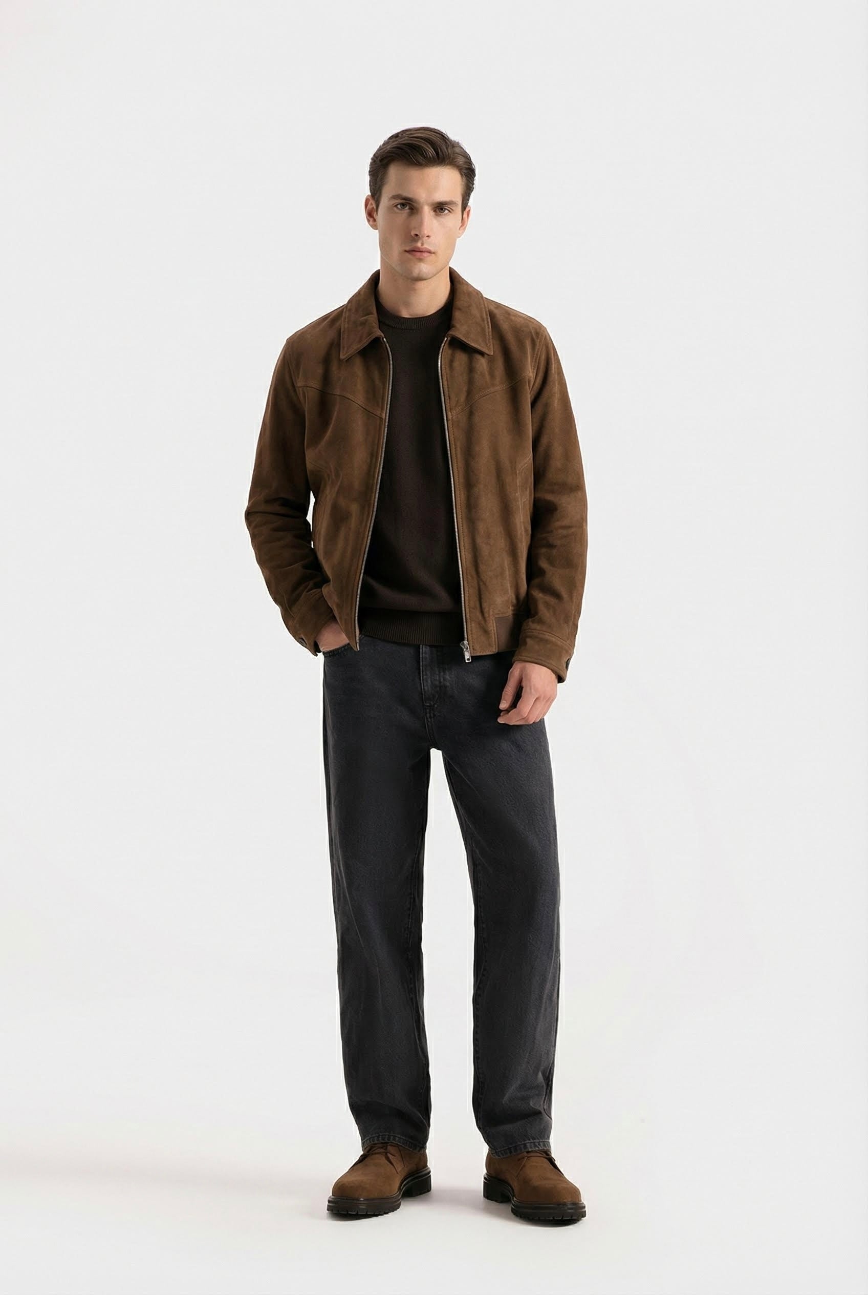 Man wearing a brown jacket and dark pants on a white background